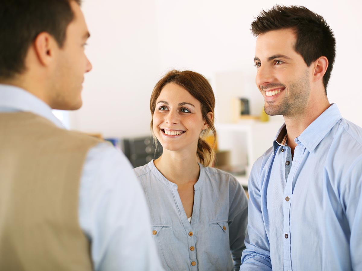 Home inspector talking to a smiling couple