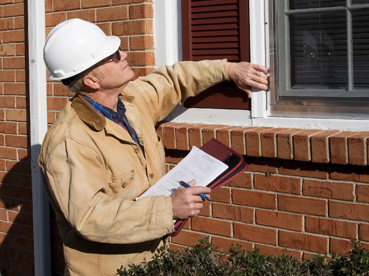 Home inspector inspecting the exterior of a home's windows