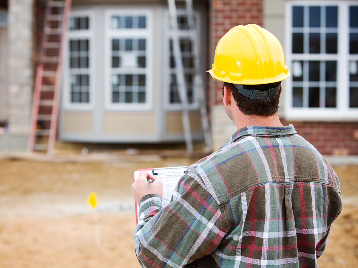 Home inspector inspecting the outside of a new construction home