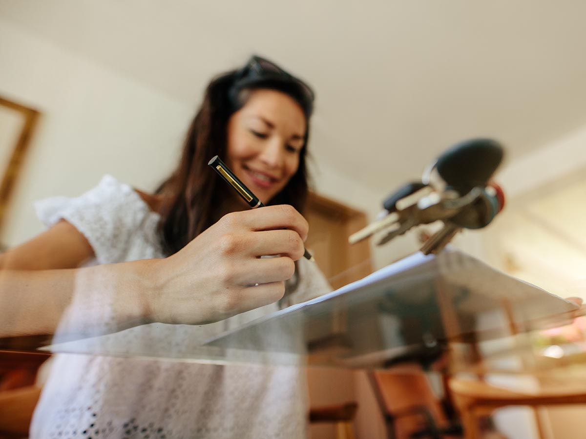 Happy woman filling out home contract agreement